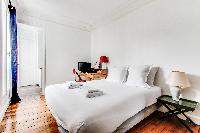 beautiful and very neat master bedroom with a queen-size bed, lamp, cabinet, TV, study desk and chai