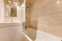 modern marble bathroom equipped with shower, toilet, and a bathtub, and a heated towel rail in a stu