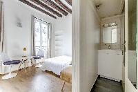 modern sleeping area, dining area, and bathroom in a studio Paris luxury apartment