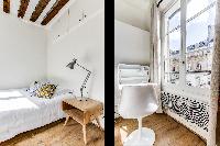 comfortable double bed and bright windows in a studio Paris luxury apartment