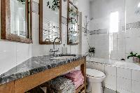 spotless modern tile and marble finished bathroom with shower, bathtub, sink, toilet, and a hairdrye