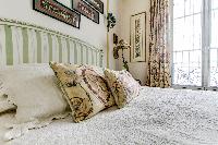 charming bedroom with a large glass window which allows natural light to pass through  in a 1-bedroo