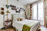 charming bedroom with a large glass window which allows natural light to pass through  in a 1-bedroo