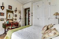 charming bedroom with ample of storage spaces and lovely decors in a 1-bedroom Paris luxury apartmen