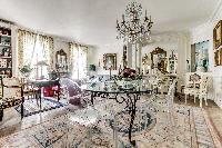 elegant dining area with a modern glass dining table and chairs for 6 in 3-bedroom Paris luxury apar