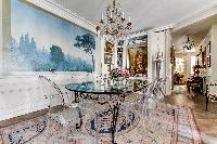 elegant dining area with a modern glass dining table and chairs for 6 in 3-bedroom Paris luxury apar