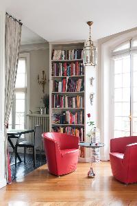 vibrant red sofa chairs and bookshelves in Paris luxury apartment