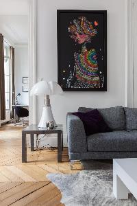 gray sofa beneath framed artwork in Paris luxury apartment