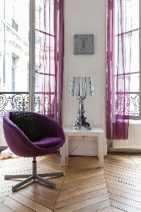 living area with shapely lamps, ornate moldings, amethyst drapes, and parquet floors in Paris luxury