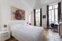 artfully decorated bedroom with queen size bed in Paris luxury apartment