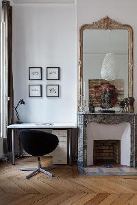 study desk beside an ornamental fireplace in Paris luxury apartment