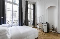 artfully decorated bedroom with queen size bed in Paris luxury apartment