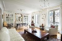 open-plan sitting and dining area with its white-painted and wood-floored space in Paris luxury apar