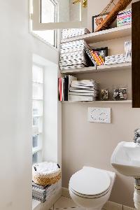 white toilet with bookshelves in Paris luxury apartment