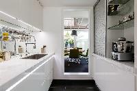 sleek white kitchen and dining area in Paris luxury apartment