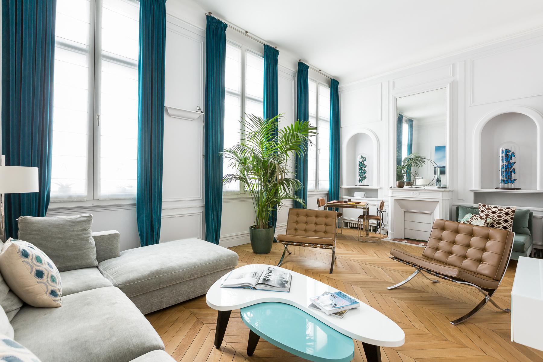 elegant living room with urquoise drapes brush against powder-blue paneling, and clean-cut sofas sit