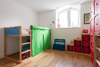 kids room with bunk bed, toys rack and cabinet in red in a Paris luxury apartment