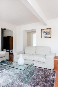 white sofa, grey rug, and glass coffee table in Paris luxury apartment