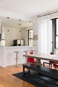 open plan dining area with breakfast bar and antique dining table beside the windows set with colour