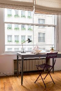 gray study and steel chair on a parquet floor in Paris luxury apartment
