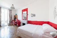 lively scarlet-and-white walled bedroom with fuchsia study desk, scarlet elaborate mirror on top of 