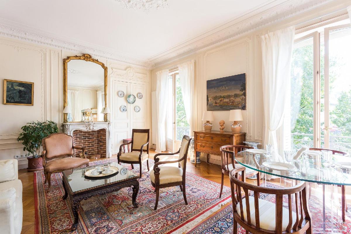elegant sitting room with the carved coffee table and dining table for 4 perch atop two richly patte