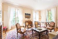 elegant sitting room with the carved coffee table and dining table for 4 perch atop two richly patte