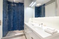 modern bathroom in its refreshing azure blue and grey hues in a Paris luxury apartment