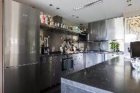 a corner kitchen with steel cabinets in a Paris luxury apartment