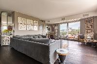 cozy living area with a collection of films and artworks, grey sofa, and spectacular view of Paris