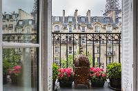 stunning view from the window withpotted flowery plants in a 2-bedroom Paris luxury apartment