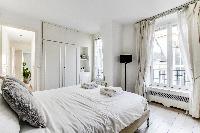 lovely bedroom with a queen-size bed and built-in closet  in a 1-bedroom Paris luxury apartment