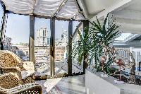 sitting area on the second level surrounded by glass doors and access to the terrace in a 1-bedroom 