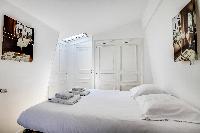 lovely bedroom with a queen-size bed, built-in closet, and skylight in a Paris luxury apartment