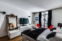 elegant master bedroom with king-size bed, two bedside tables, chairs, media shelf, flat screen tele