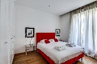 cozy bedroom with a queen-size bed, two-bed side tables, and built-in cabinets  in paris luxury apar