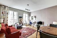 living room with bright windows, cozy sofa bed placed in front of the television, a music player, an