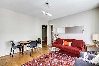 living area with bright windows, cozy sofa bed placed in front of the television, a music player, a 