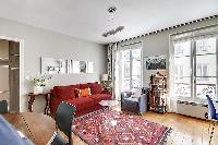 living area with bright windows, cozy sofa bed placed in front of the television, a music player, a 