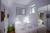 chic bedroom with a double bed and a closet with door mirrors in a Paris luxury apartment