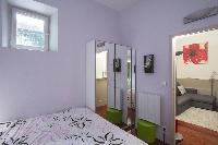chic bedroom with a double bed and a closet with door mirrors in a Paris luxury apartment