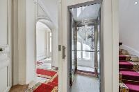 white-walled hallway and carpeted stairs leads to Paris luxury apartment