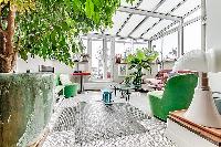 a sunroom, a unique feature, made of glass windows and green vegetation in a Paris luxury apartment