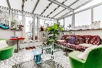 a sunroom, a unique feature, made of glass windows and green vegetation in a Paris luxury apartment