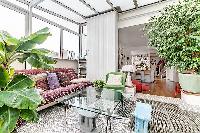 a sunroom, a unique feature, made of glass windows and green vegetation in a Paris luxury apartment