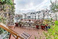 outdoor terrace with views of Parisian rooftops in a Paris luxury apartment