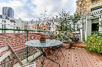 outdoor terrace with views of Parisian rooftops in a Paris luxury apartment