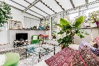 a sunroom, a unique feature, made of glass windows and green vegetation in a Paris luxury apartment