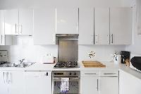 immaculate white fully-equipped kitchen in a 3-bedroom Paris luxury apartment