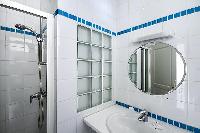 second bathroom with a shower area, a sink, and a toilet in a 3-bedroom Paris luxury apartment